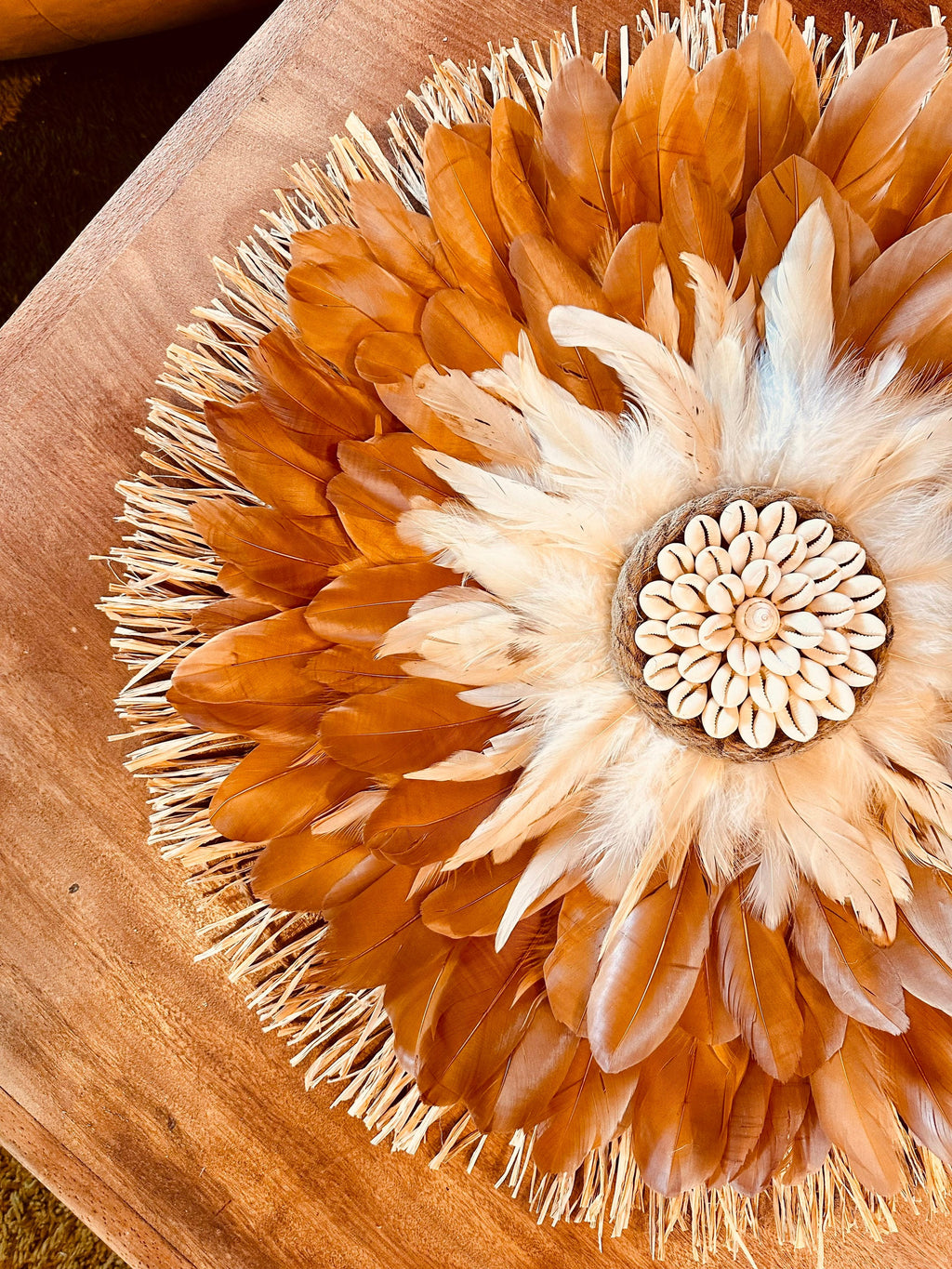 Jujuhat « LE MARTINIQUAIS » – décoration murale en plumes marron et beige, cœur en coquillages cauris et raphia naturel