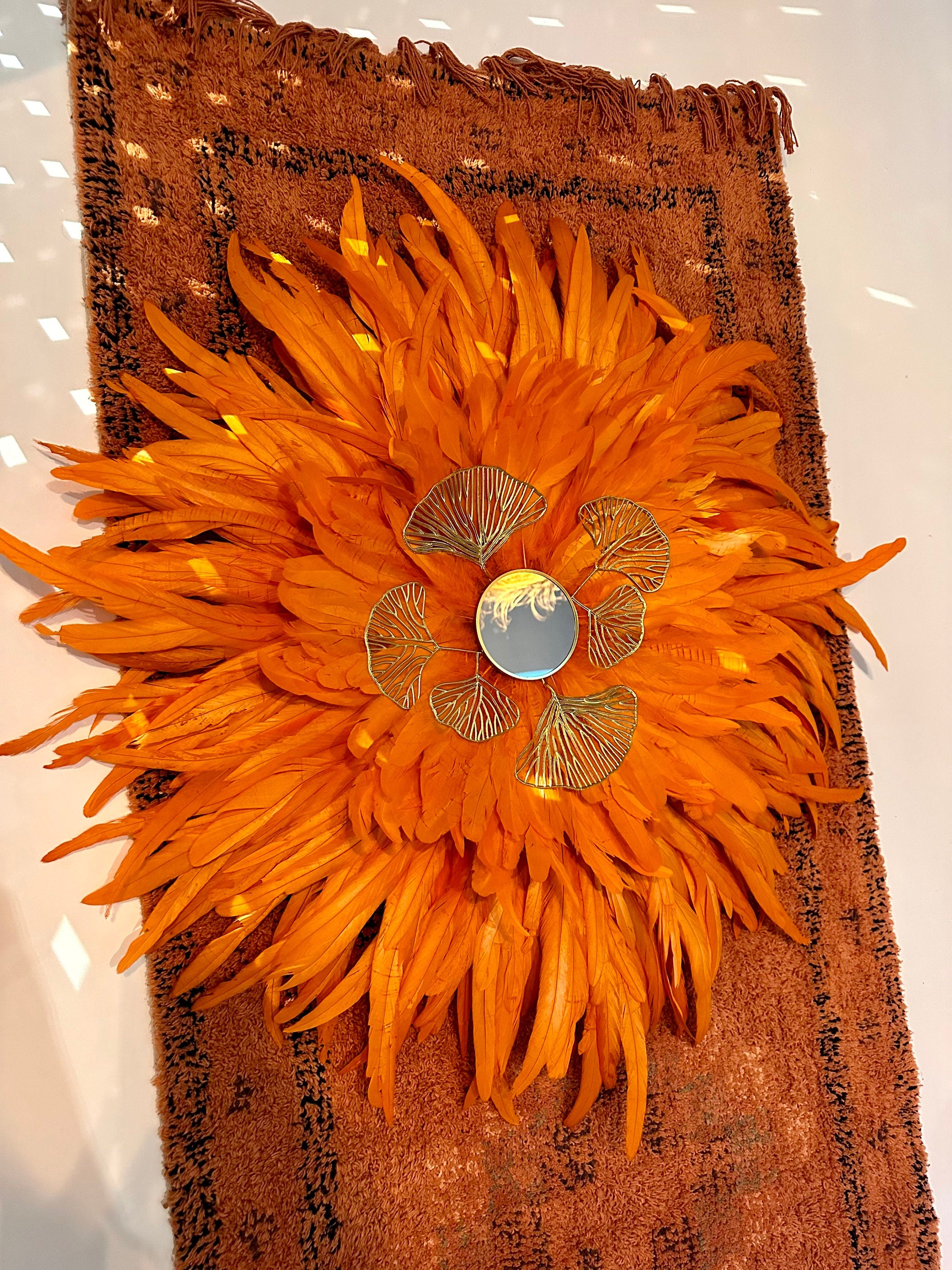 Juju Hat “LE BAHIA” – Plumes orange vif et miroir doré – Déco murale ethnique chic – Fait main – 70 cm