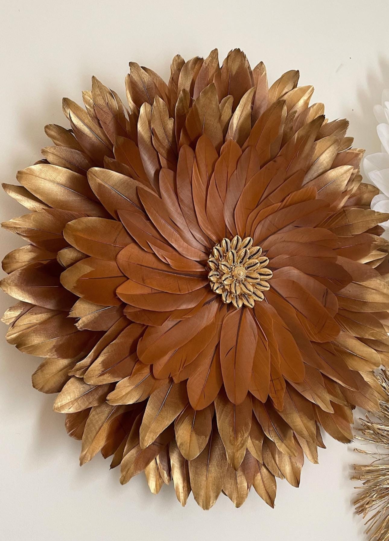 JUJUHAT "GOLDEN CHOCOLAT" avec ses plumes marron aux pointes dorées et son coeur en coquillages cauris dorés