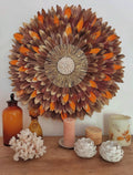 JUJUHAT “MILLE FEUX” – Déco murale en plumes marron, orange et doré • Raphia doré & cauris • 50, 65 ou 80 cm